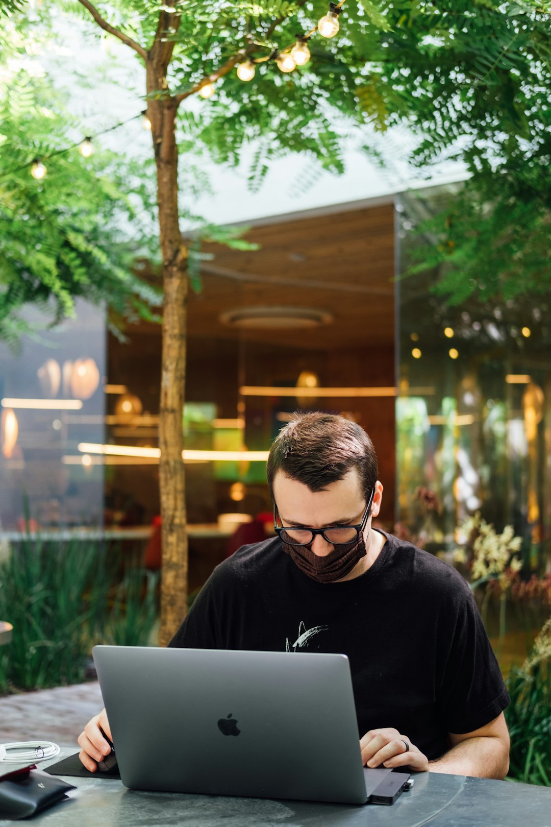 A designer working outdoors on a laptop.